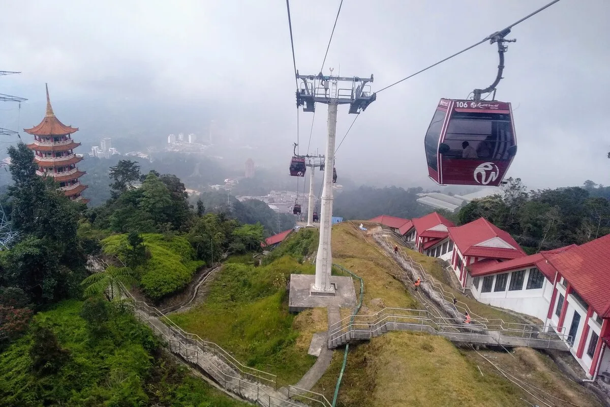 Awana SkyWay cable car cabin passing the Chin Swee Temple pagoda in mist