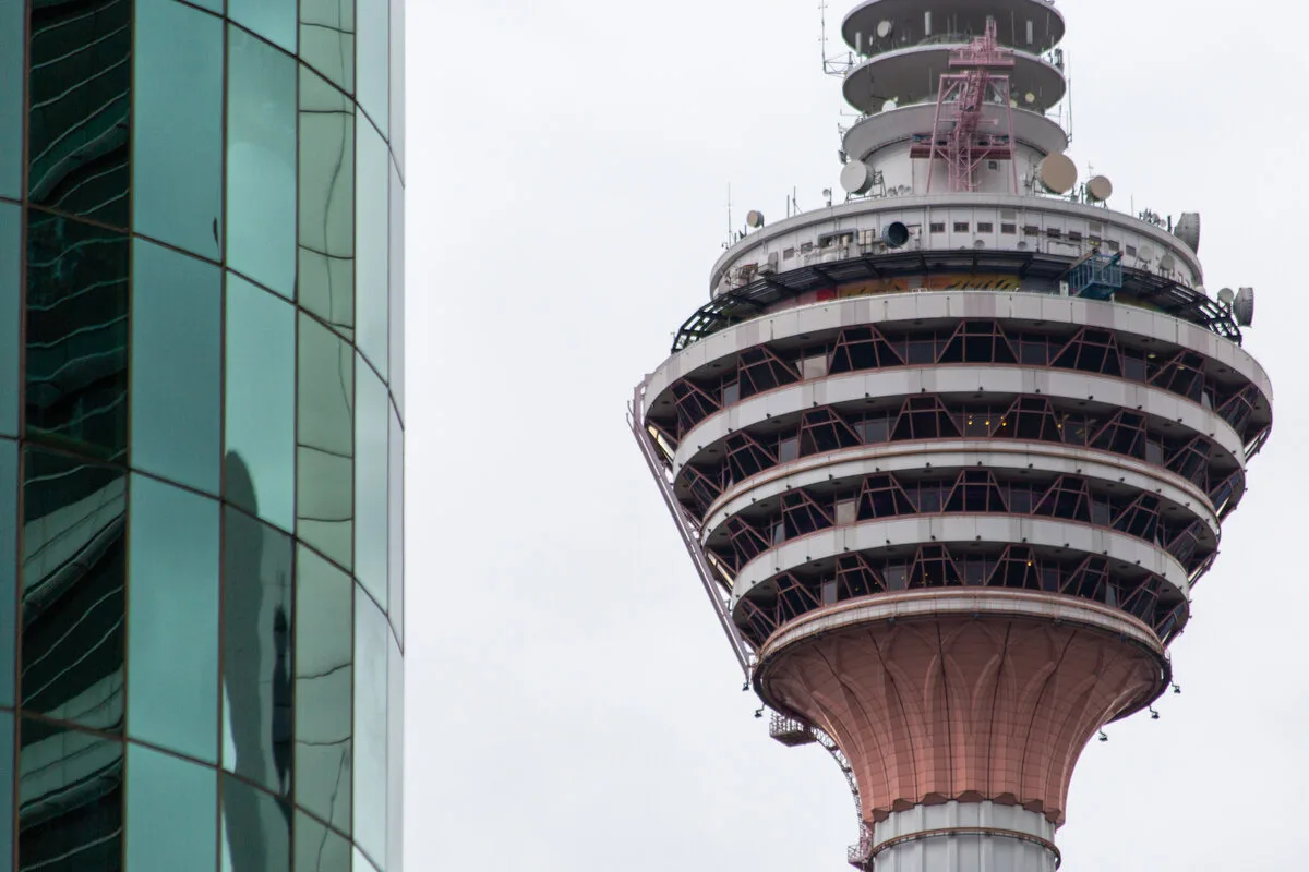 Close-up of the KL Tower observation pod and antenna against a pale sky