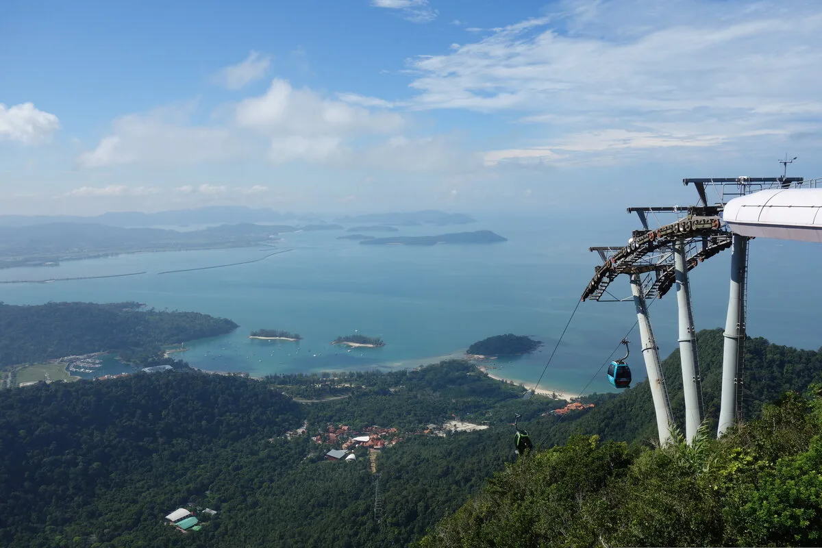 Langkawi SkyCab gondola leaving the top station above forest, sea and islands