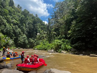 "Two groups of adventurers experiencing the thrill of white water rafting in Bali, navigating the fast-flowing river with excitement and teamwork. An action-packed water activity that combines nature and adventure."