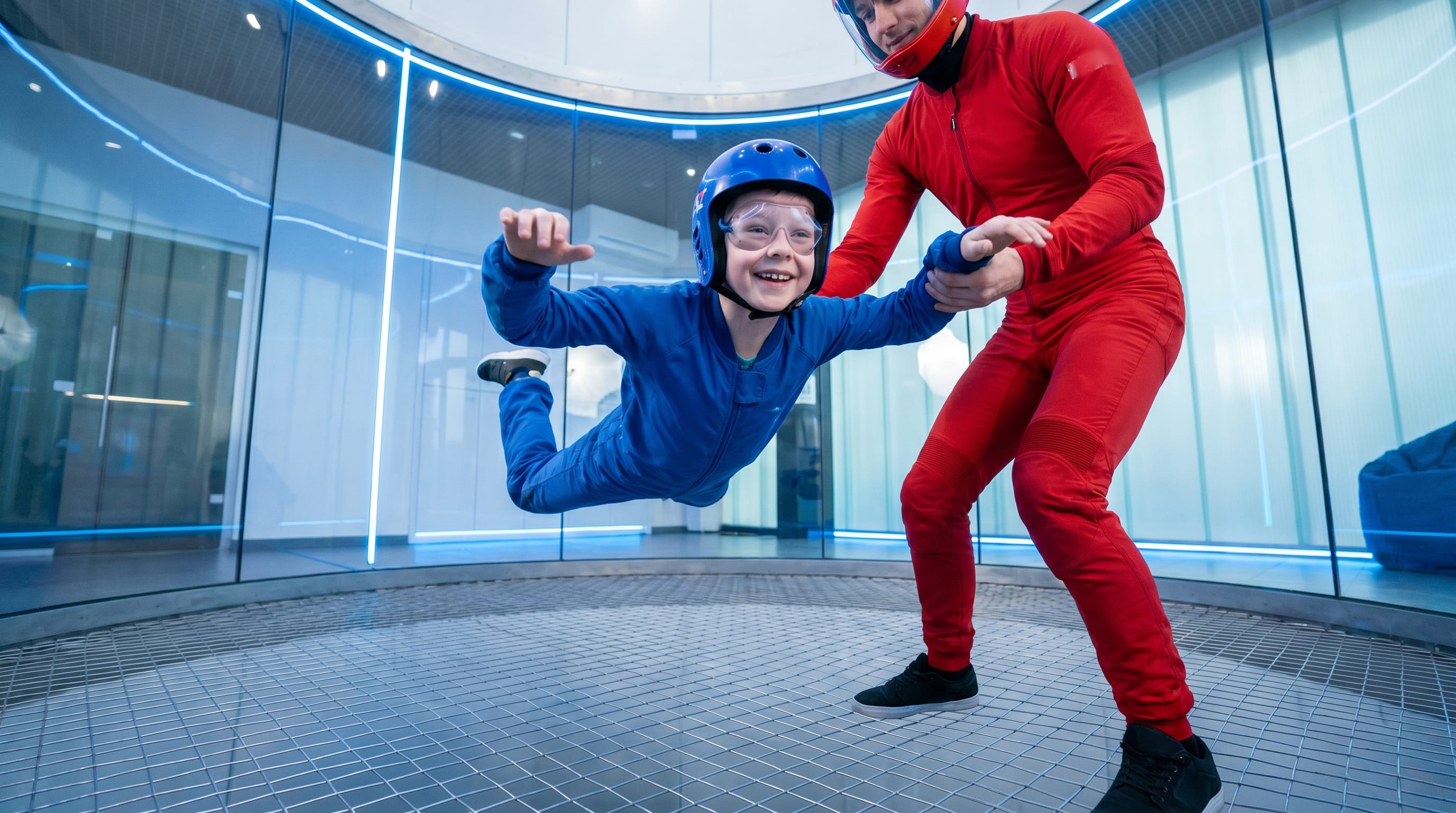 Young child indoor skydiving at iFly Singapore with instructor support in the wind tunnel