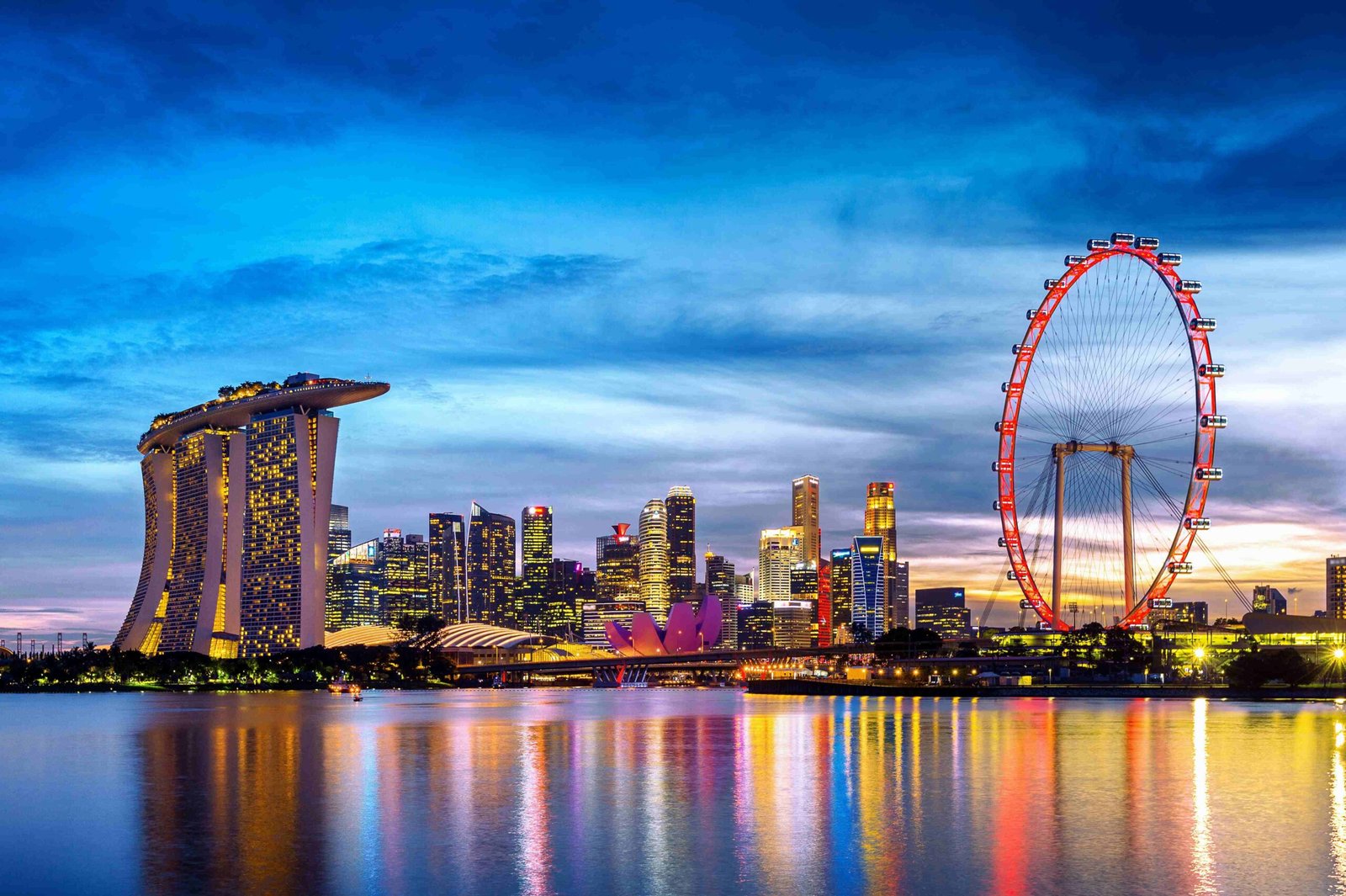 Marina Bay Sands and Singapore Flyer at twilight with city skyline reflection. 5 best places to visit in Singapore. Singapore tour package