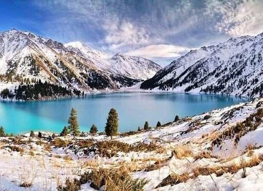 Big Almaty Lake surrounded by snow-capped mountains in the Tian Shan range during winter, featuring turquoise water and scenic landscapes picture Source: Pinterest