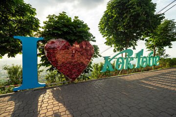 I Love Kok Tobe" installation at Kok Tobe Hill Almaty, surrounded by greenery and scenic views, showcasing the iconic charm and beauty of the tourist attraction.