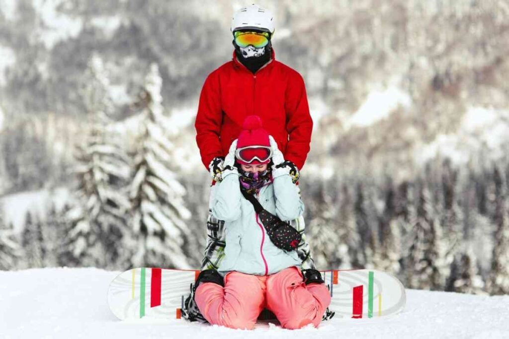 Couple  celebrating on a snowy mountain peak with surrounded by stunning alpine scenery.