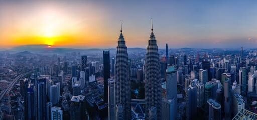 Panoramic view of the iconic Petronas Twin Towers Malaysia at sunset, showcasing Kuala Lumpur's breathtaking skyline and architectural brilliance.