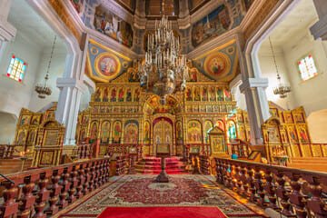 Things to do in Almaty: A scenic view of Panfilov Park featuring the vibrant Zenkov Cathedral surrounded by lush greenery, highlighting the park's cultural and historical significance as a must-visit destination.