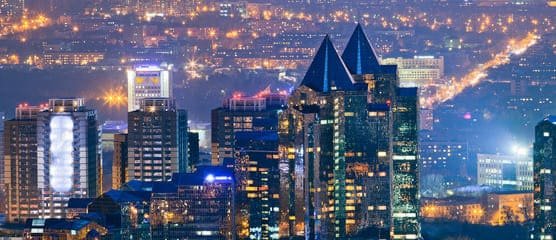 Vibrant Almaty nightlife scene with illuminated city lights, lively bars, and rooftop venues offering breathtaking views, a must-experience.