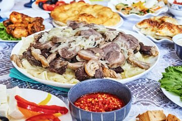 Traditional Kazakh cuisine served at a vibrant table in Almaty, showcasing cultural heritage and reasons to visit Almaty, Kazakhstan.