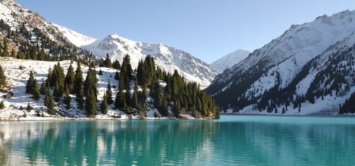 Big Almaty Lake surrounded by snow-capped mountains and lush greenery, offering a serene and breathtaking view - a must-visit spot on your 3-day Almaty itinerary.