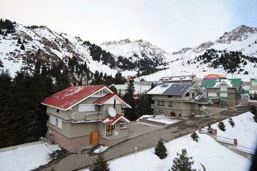 Scenic view of Shymbulak Ski Resort with cozy chalets surrounded by snow-covered mountains, perfect for a romantic getaway in Almaty.